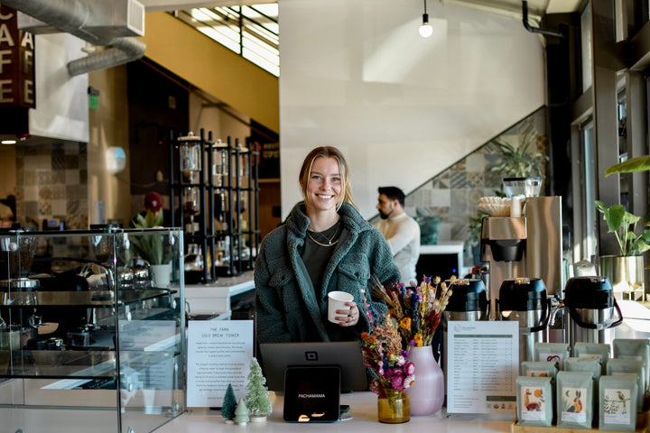 woman smiling at coffee shop counter in Sacramento Natural Foods Coop