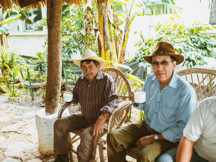 farmers in Guatemala sit and drink coffee