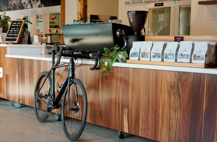 Bike parked in coffee shop in front of slayer espresso machine