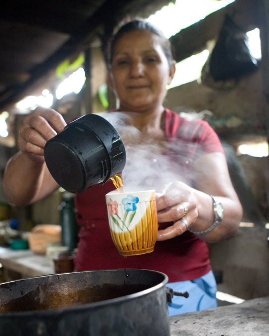 woman pouring coffee into mug in her home in nicaragua