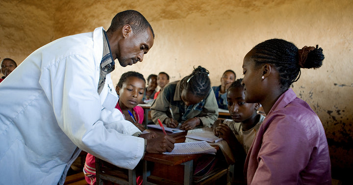 teacher grading a students work in an Ethiopian school